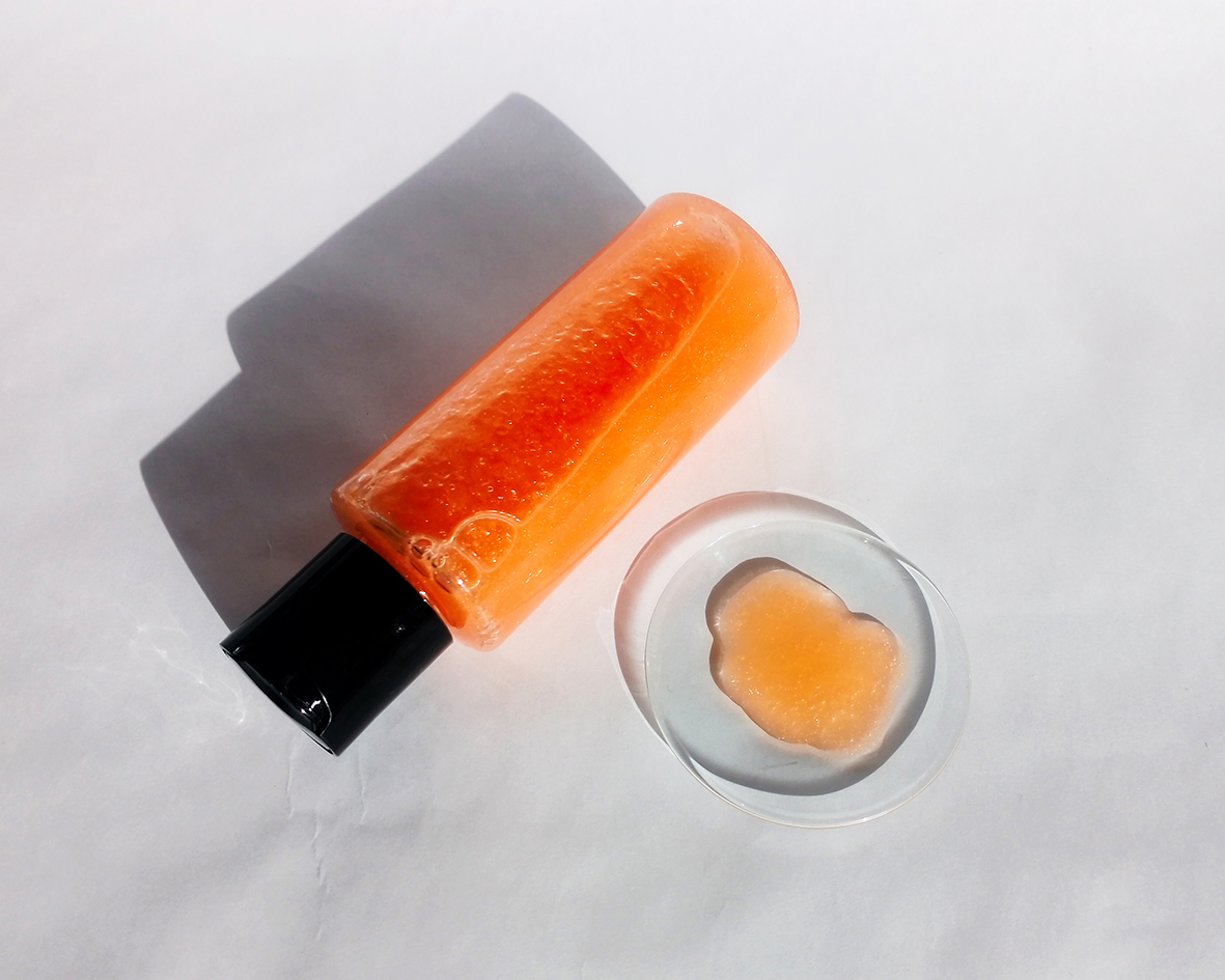 Osviežujúci sprchový gél v priehľadnej fľaške so sýtou oranžovou farbou na bielom pozadí.